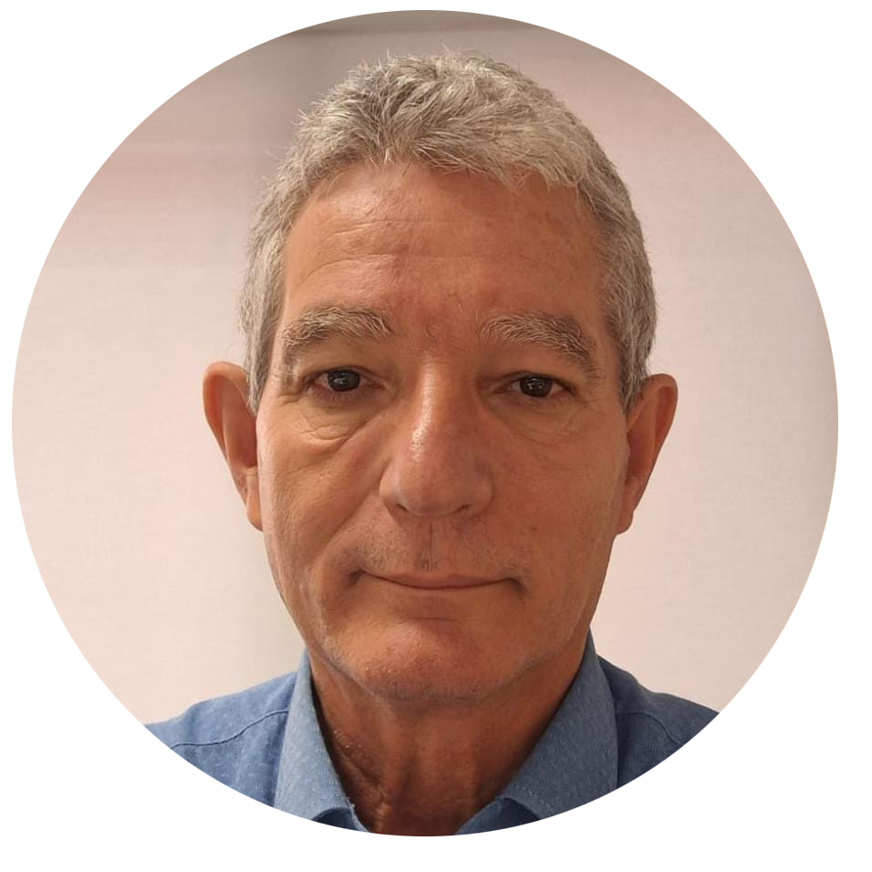 Homem de pele clara e cabelos curtos, grisalhos. Está sem barba ou bigode. Veste camisa azul.